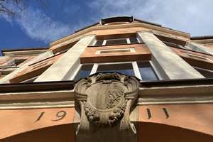 Foto Schulgebäude Blickrichtung Haupteingang entlang der Fassade in den Himmel